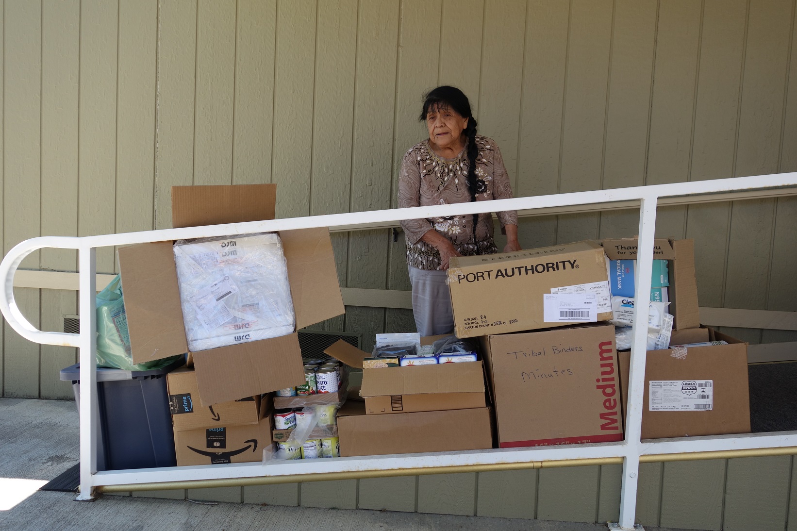 California Valley Miwok Tribe elder Mildred Burley standing in front of good supplies during June 2021 Food For Tribal Families Distribution