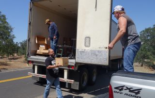 Tiger Paulk helps unloading good supplies with Tule River food distribution staff