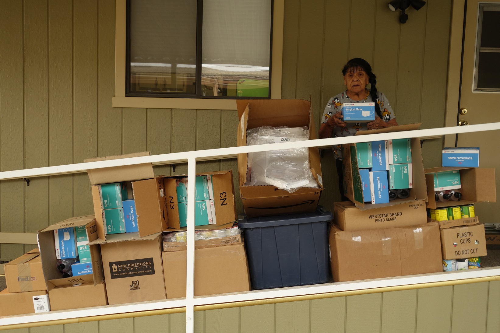 Mildred Burley, California Valley Miwok Tribe's elder, standing with good supplies from July 2021 food distribution.