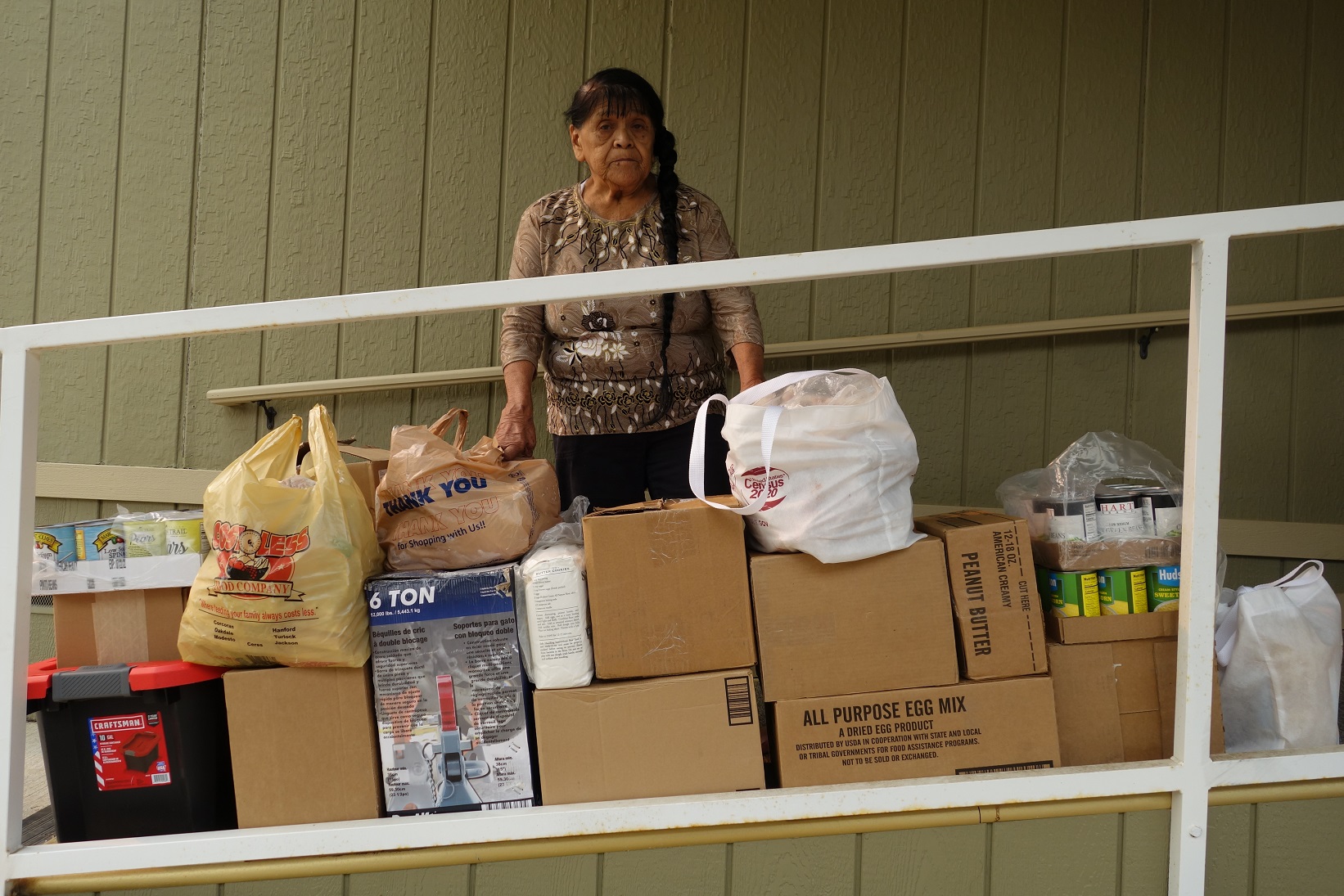 California Valley Miwok Tribal elder Mildred Burley standing with lots of donated good supplies.