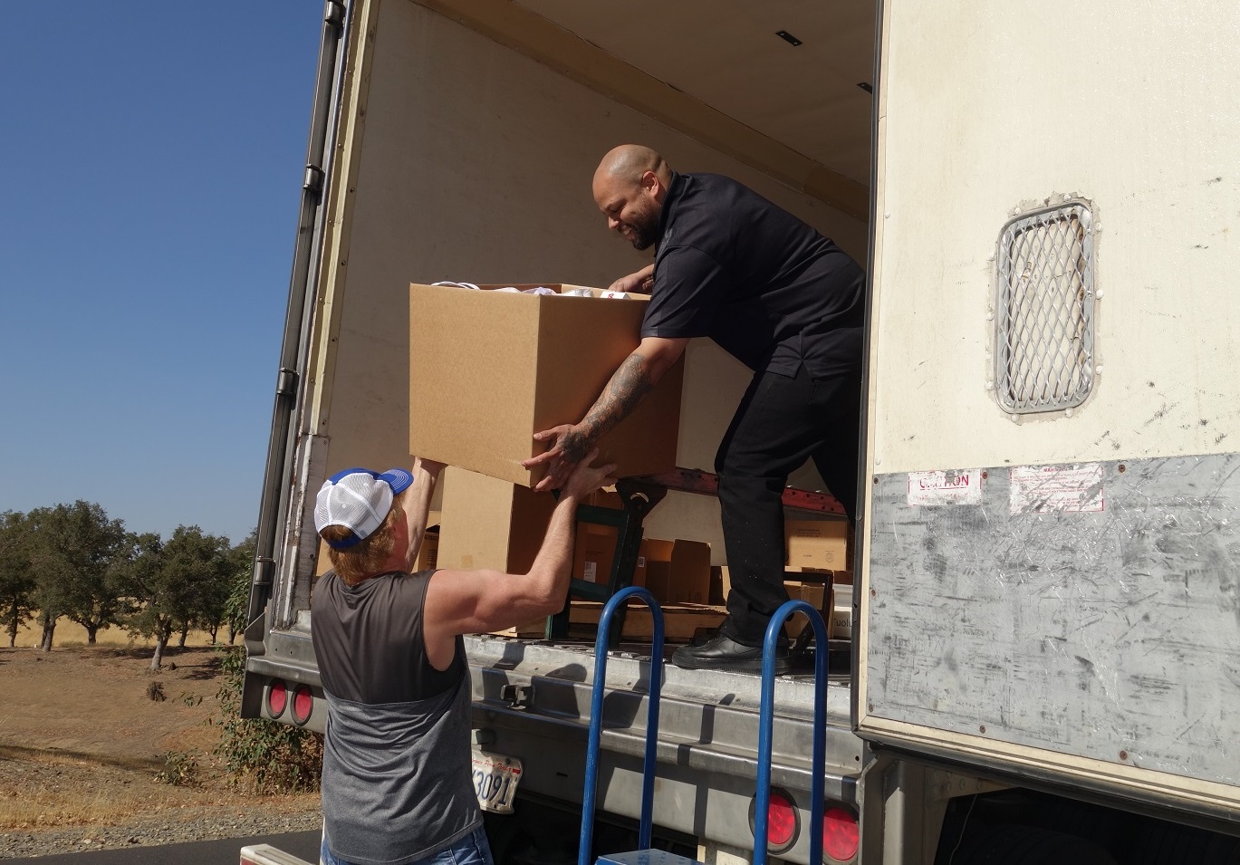 Tule River Food Distribution Specialist Naz helping Tiger Paulk unloading good supplies for the California Valley Miwok Tribe.