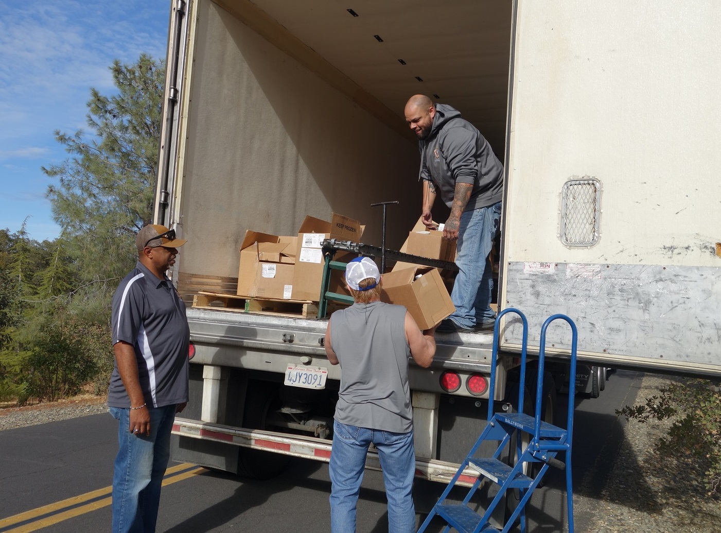 Tule River Food Distribution Specialists helping California Valley Miwok Tribal staff Tiger Paulk to unload good supplies.