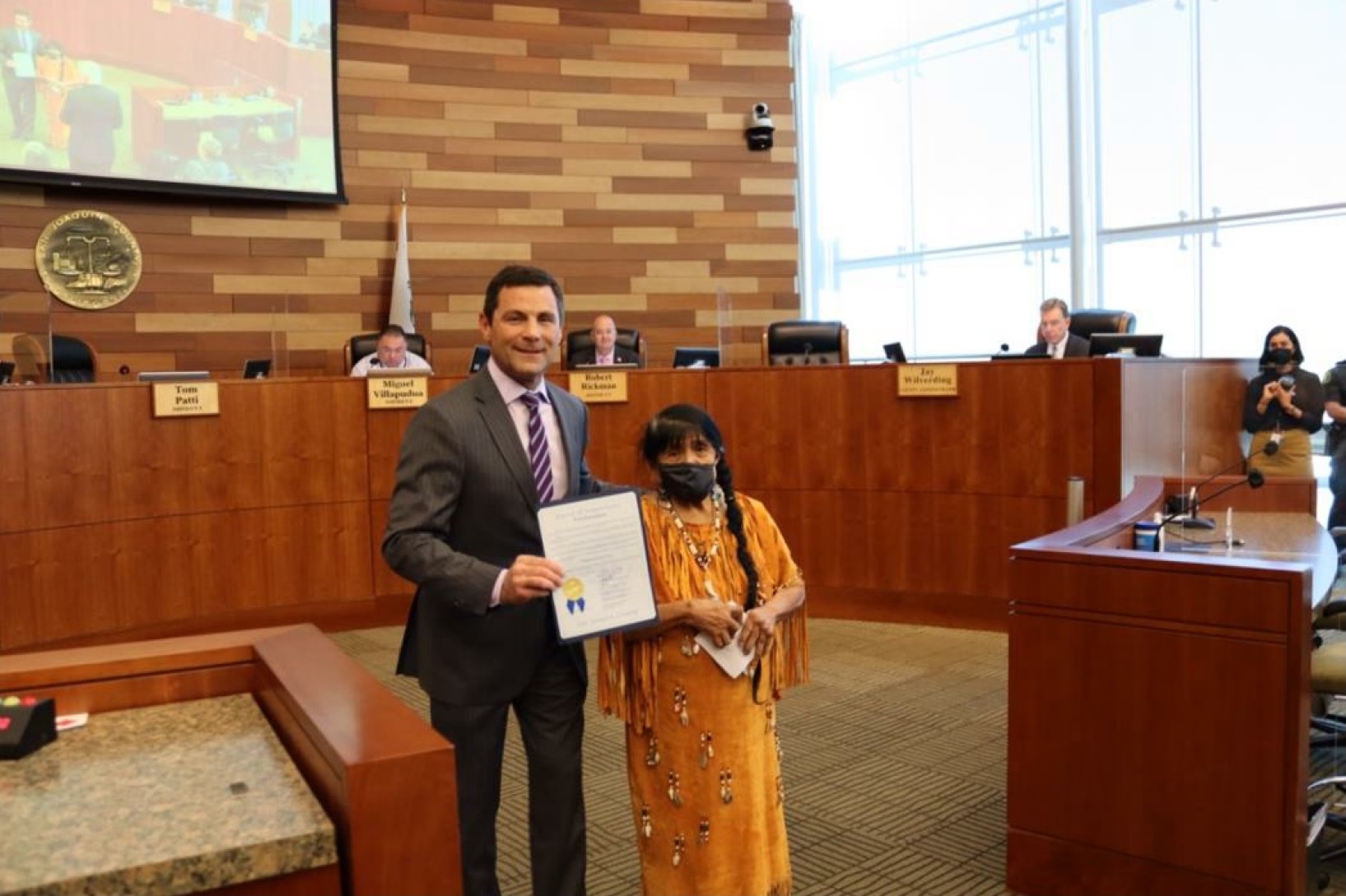 California Valley Miwok Tribal elder Mildred Burley with Tom Patti, holding the Indigenous Peoples’ Day proclamation.