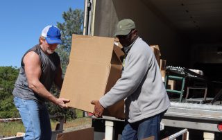 Ronald Buckman and Tiger Paulk unloading big boxes during a food distribution for the California Valley Miwok Tribe.