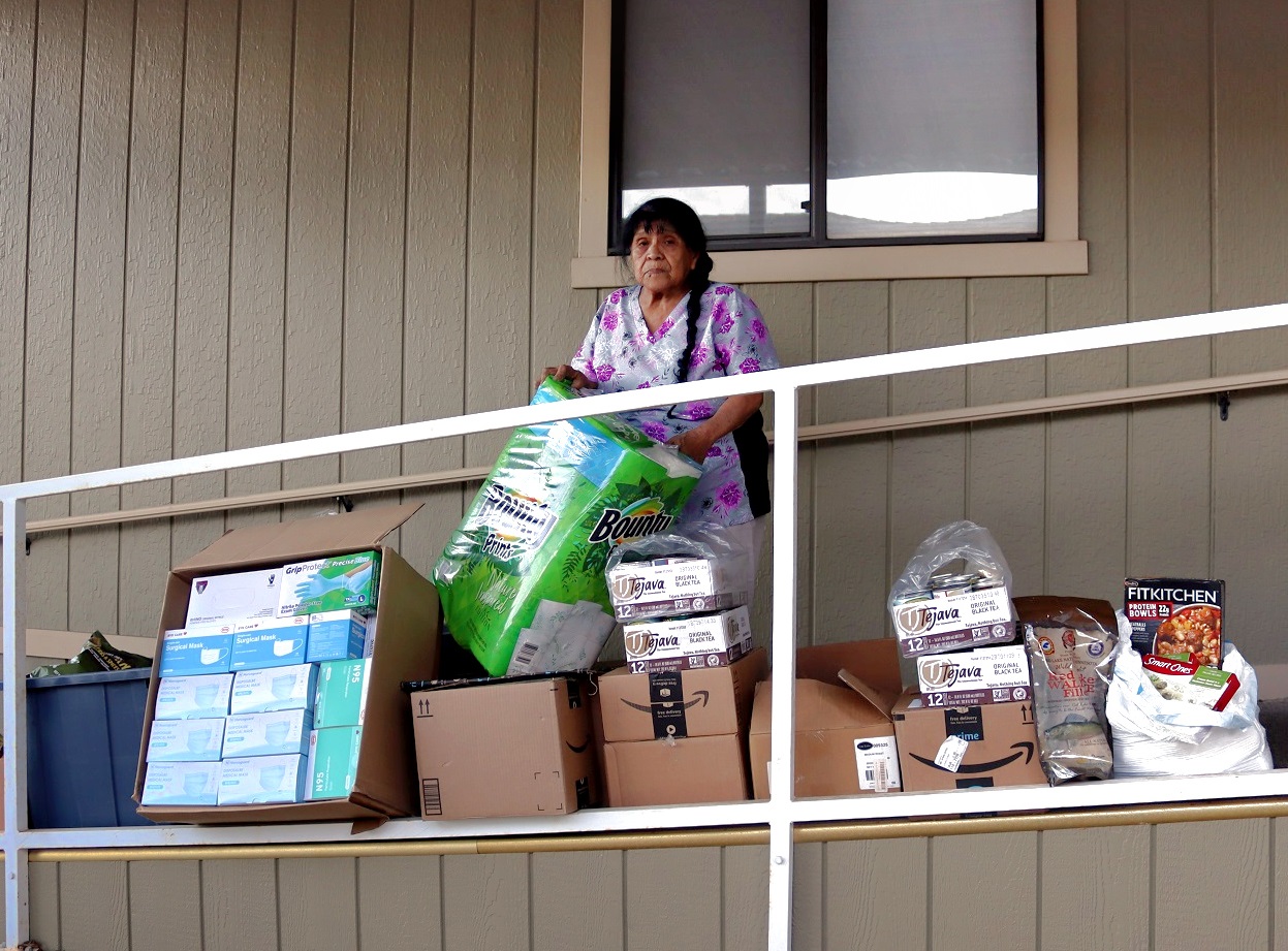 California Valley Miwok Tribe's elder Mildred Burley standing with donations from the Food For Tribal Families Program