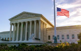 American flag flying at half-staff in front of the Supreme Court in Washington.