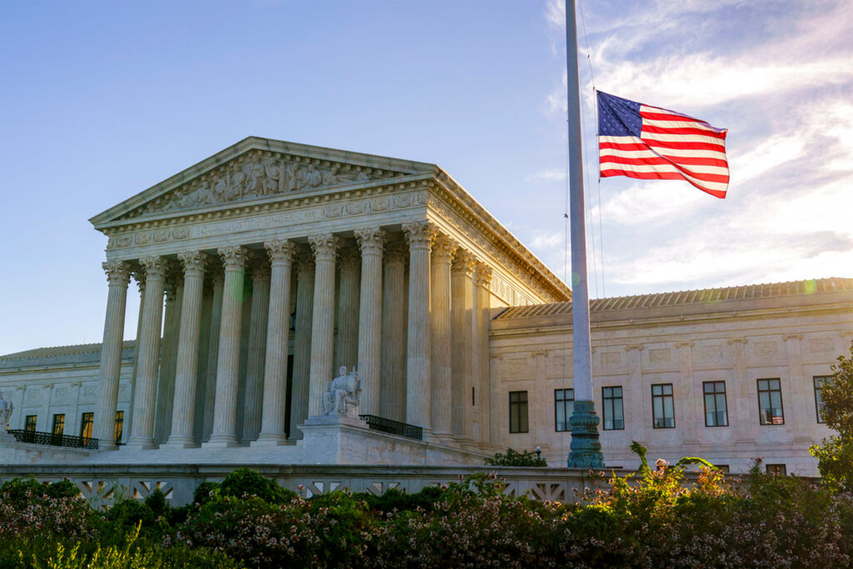 American flag flying at half-staff in front of the Supreme Court in Washington.