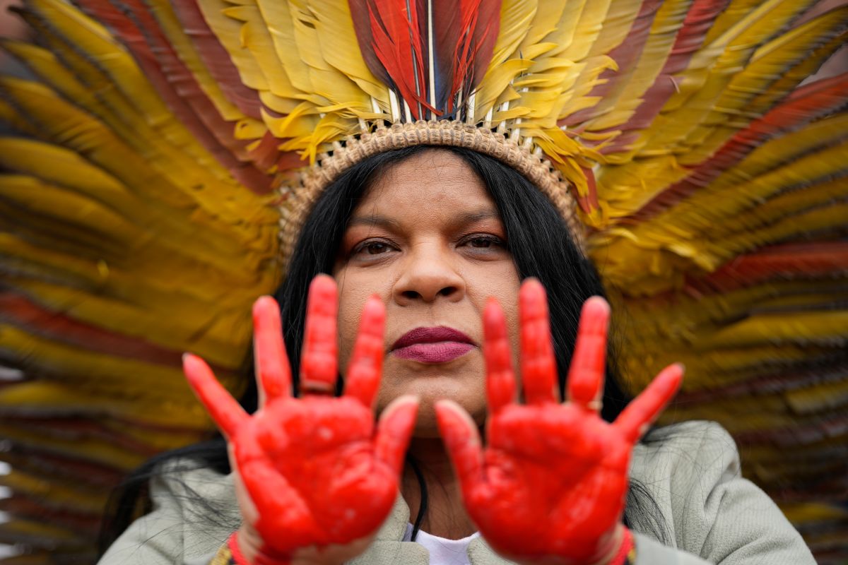 Indigenous leader Sonia Guajajara from the Guajajara ethnic group shows her hands painted in red symbolizing bloodshed.