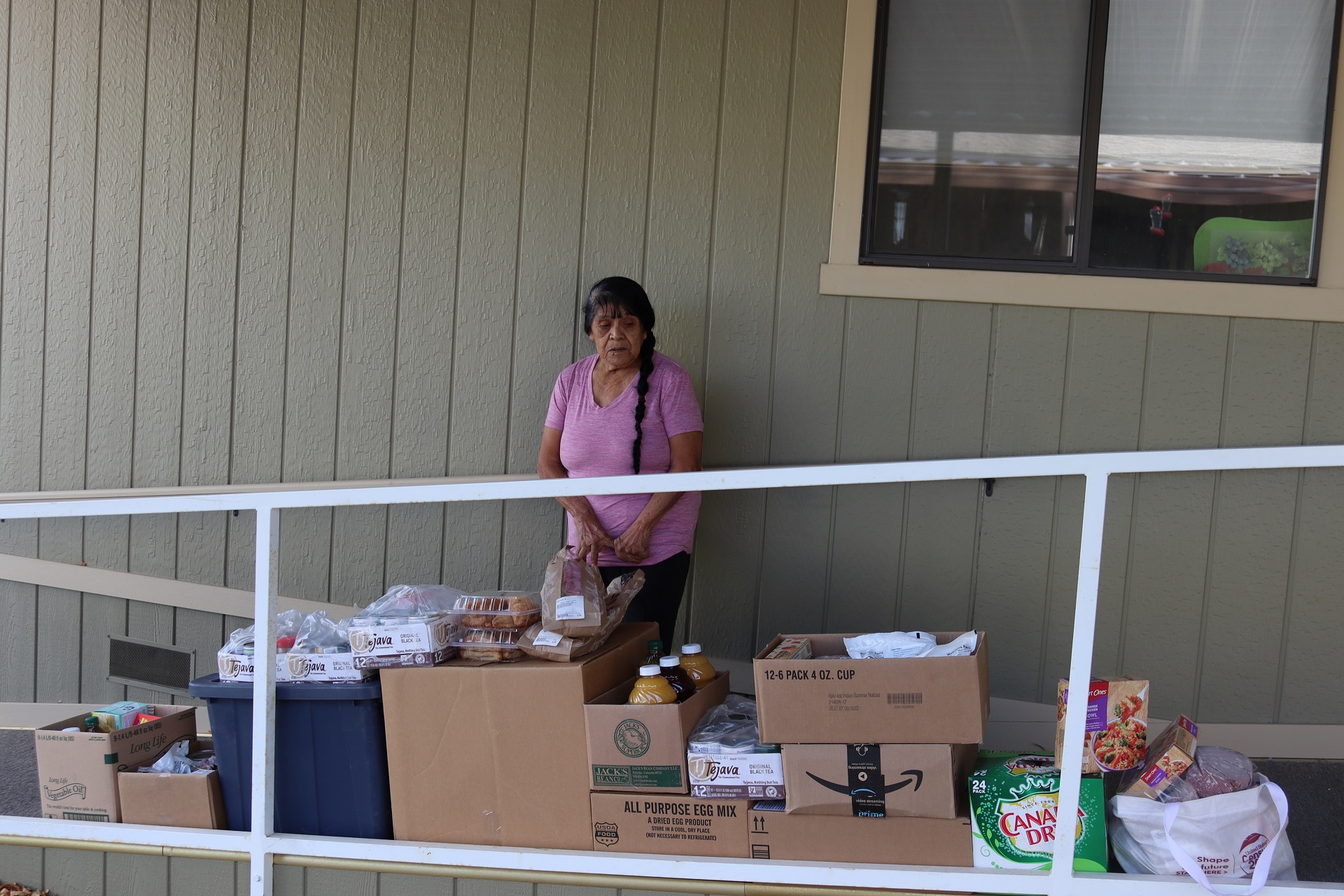 Native American elder Mildred Burley in front of delivery goods for tribal families.