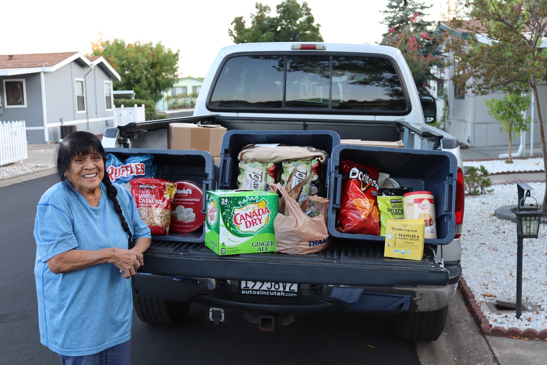 Tribal elder Mildred Burley with goods being delivered to Miwok tribe members.