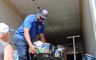 Ronald Buckman helping tribal member Tiger Paulk unloading goods for the California Valley Miwok Tribe.