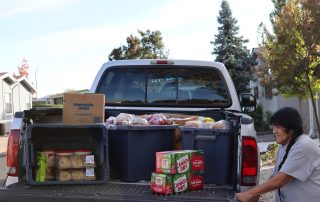 California Valley Miwok tribal elder Mildred Burley seen with truck full of goods during the FFTF distribution in October 2024.