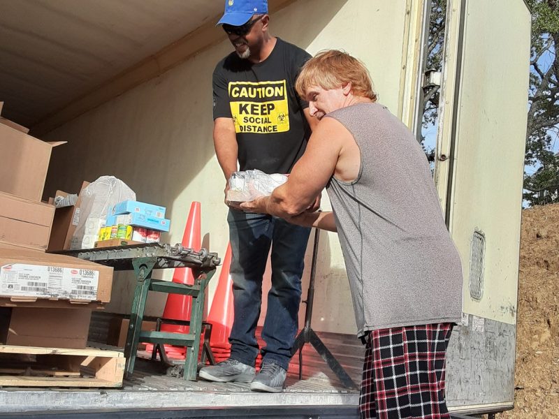 USDA Food Specialist Ronald Buckman and tribal staff keep a safe distance while also turning their heads while transferring food. June 2020 USDA Food Distribution