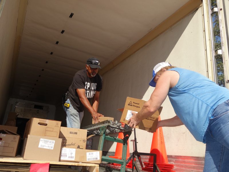 USDA Distribution Specialist, Ronald Buckman seen working with tribal staff, "at a safe and prescribed distance".