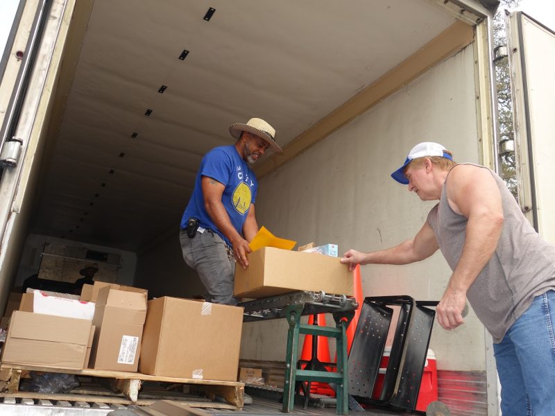 Tule River Specialist Ronald Buckman pushing product down conveyor to CVMT tribal staff while keeping social distancing.