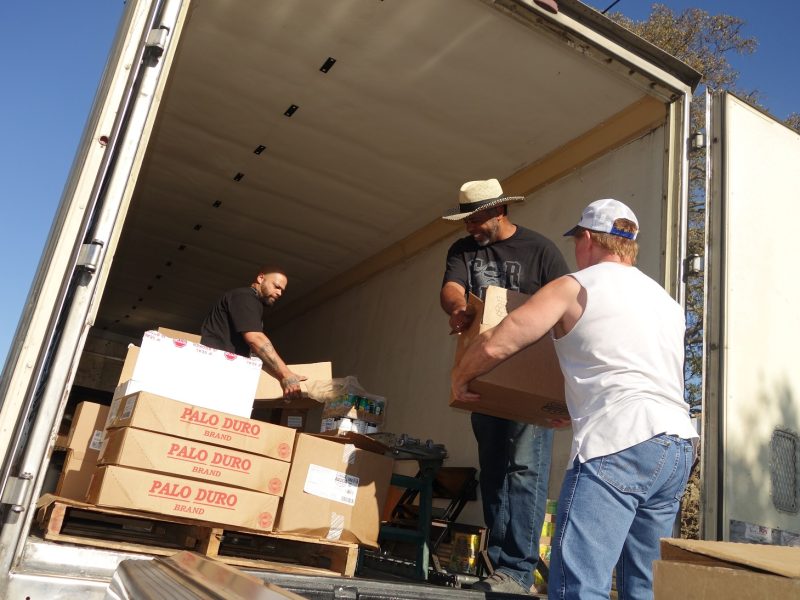 Specialist Ronald Buckman is seen here working with tribal staff as Specialist Naz in the background is loading conveyor.