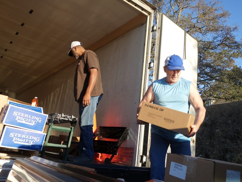 Tribal personnel loading last of one family's distribution as Specialist Ronald Buckman waits for Naz to push next distribution down the conveyor.