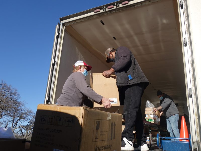 Near the end of the day Specialist Ronald Buckman passes product off to tribal staff as Specialist Naz brings down the last of the day's distributions.