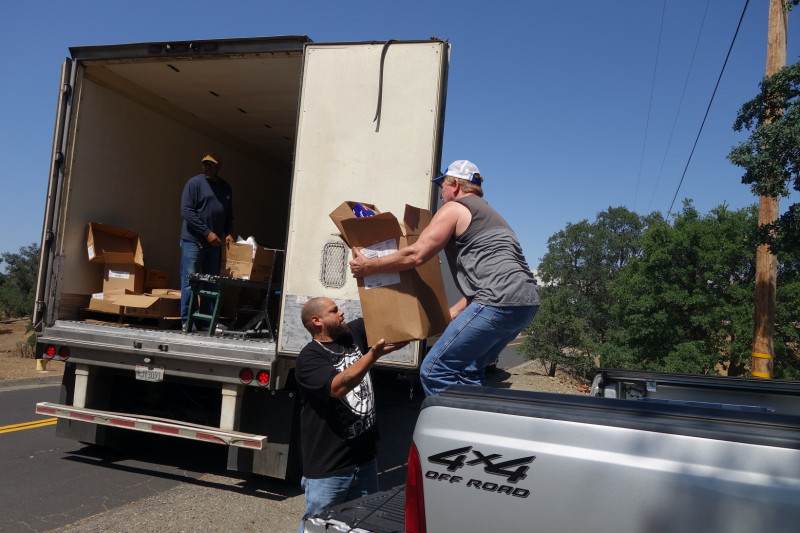With one distribution ending as Specialist, ( Naz ) works with tribal staff specialist Ronald Buckman has next distribution prepared to go. California Valley Miwok Tribe staff member Tiger Paulk lifts a box good supplies on the back of a truck