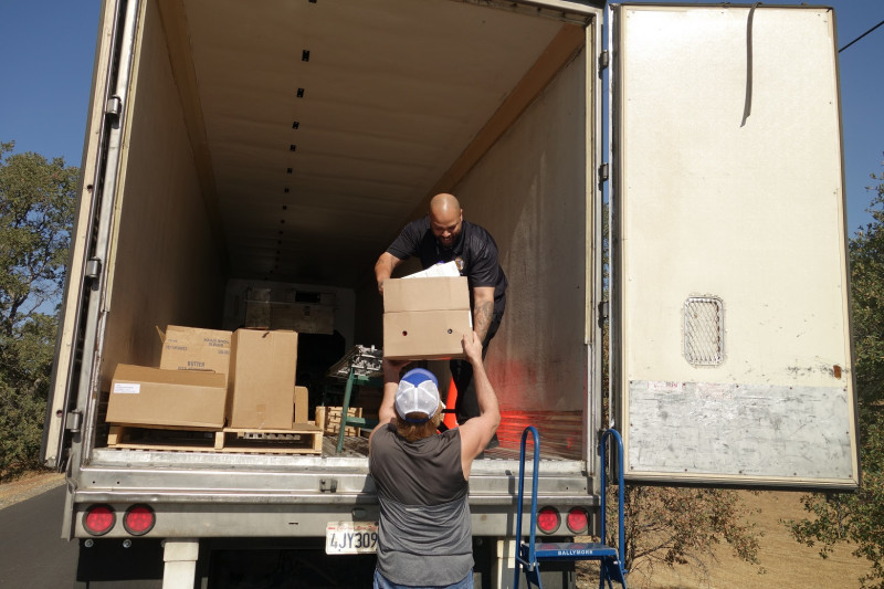 Tule River Distribution Specialist Naz hands one of a family's many boxes of their distribution to tribal staff. California Valley Miwok Tribe's staff delivering good supplies.
