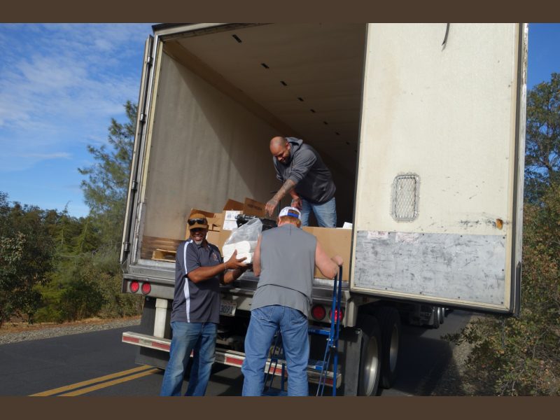 Tule River Food Distribution Specialists helping California Valley Miwok Tribal staff Tiger Paulk to unload good supplies.