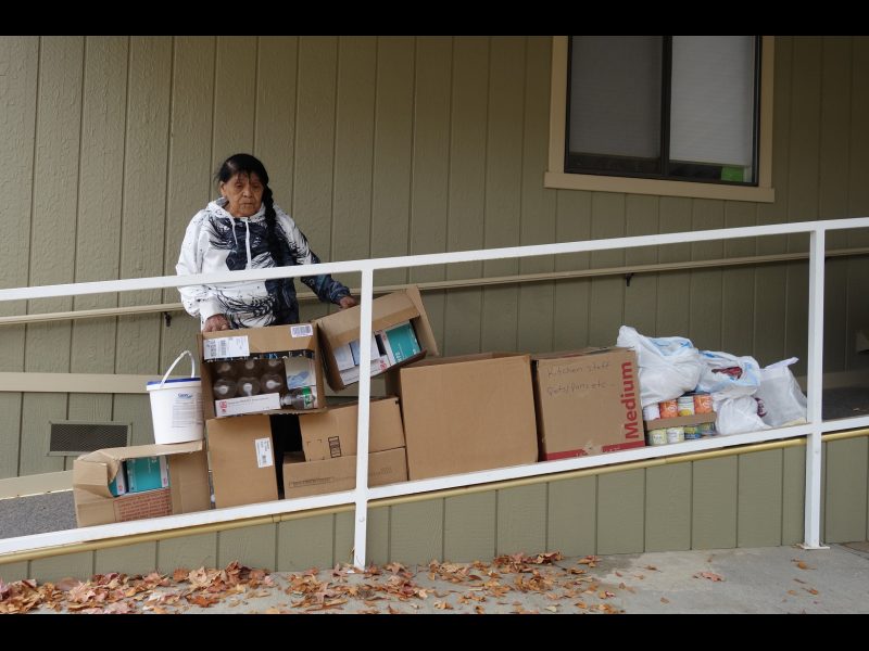 Tribal Elder and Food For Tribal Families, Program Director Mildred Burley, stands just behind a big influx of much needed Covid supplies. California Valley Miwok Tribal elder Mildred Burley with good supplies from the Food For Tribal Families program.