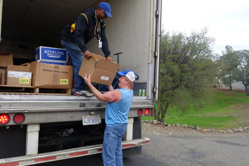 Food drive starting out, hard to hold box while laughing as Specialist, "Ronald Buckman" makes a light hearted joke as, "Gitmo" from his old stand up comedy routine. California Valley Miwok Tribe's staff delivering good supplies.