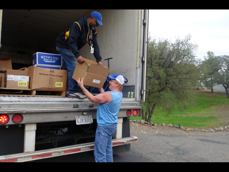 Food drive starting out, hard to hold box while laughing as Specialist, "Ronald Buckman" makes a light hearted joke as, "Gitmo" from his old stand up comedy routine. California Valley Miwok Tribe's staff delivering good supplies.