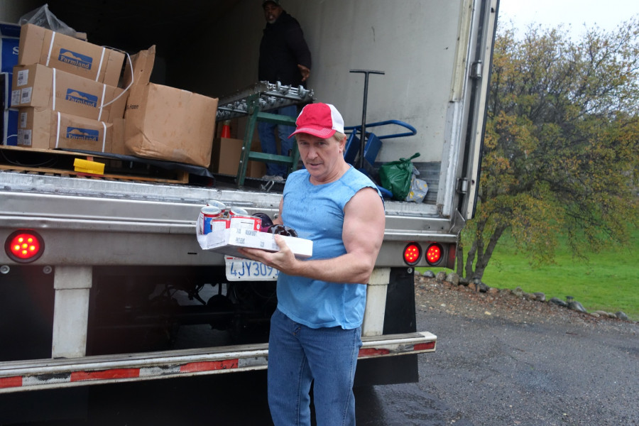 During distribution, Specialist Ronald Buckman and a tribal staffer were caught by surprise as with the intermittent rain they did not realize pictures would be taken. California Valley Miwok Tribe's staff unloading goods during a USDA Food Distribution.