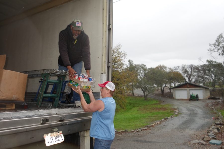 Specialist Ronald Buckman handing some canned goods down to tribal staff. California Valley Miwok Tribe's staff unloading goods during a USDA Food Distribution.