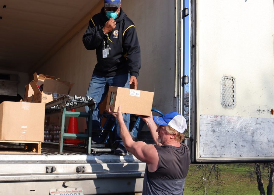Covid protocols in place for food deliveries and recipient safety have Specialist Ronald Buckman
sporting one of the newer N-95 3M masks. California Valley Miwok Tribe's staff unloading goods during a USDA Food Distribution.