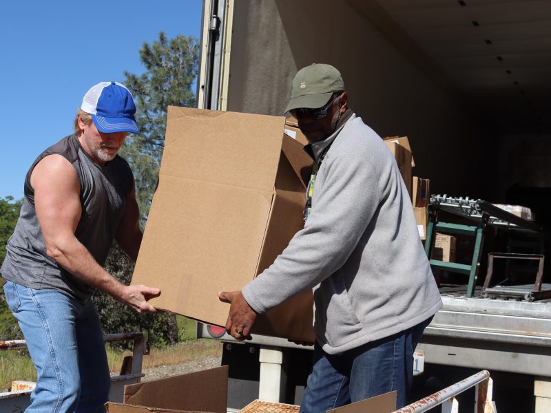 Last two boxes of the day were very full and awkward so Specialist Ronald Buckman assisted tribal staff. Ronald Buckman and Tiger Paulk unloading big boxes during a food distribution for the California Valley Miwok Tribe.
