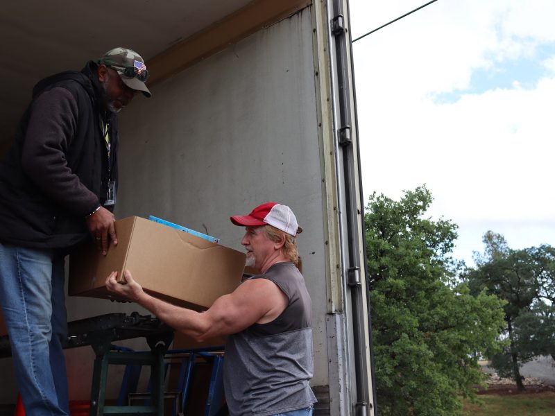 Tule River Specialist, Ronald Buckman hands one of the many boxes of
wholesome foods to tribal staff. Ronald Buckman handing tribal staff member Tiger Paulk goods for the California Valley Miwok Tribe.