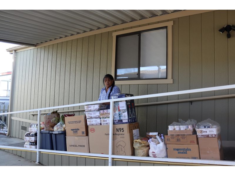 California Indian tribe elder Mildred Burley standing in front of food supplies for the California Valley Miwok Tribe.