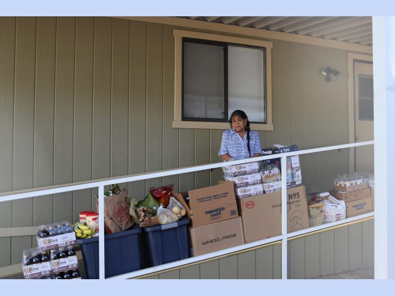 California Indian tribe elder Mildred Burley standing in front of food supplies for the California Valley Miwok Tribe.
