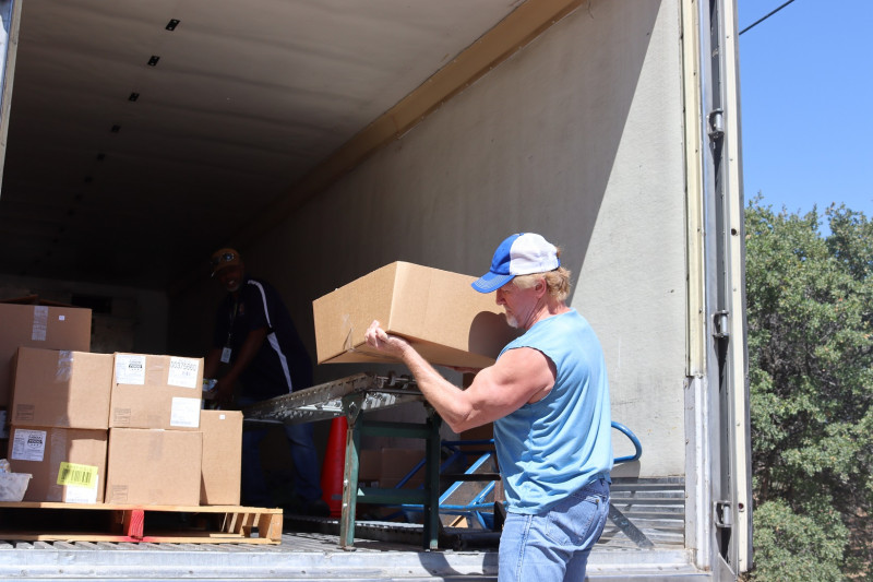 Tule River Food Specialist, "Ronald Buckman" loads conveyor as tribal staff load the last of one recipients distribution. California Valley Miwok Tribe's Tiger Paulk loading food supplies on a conveyor