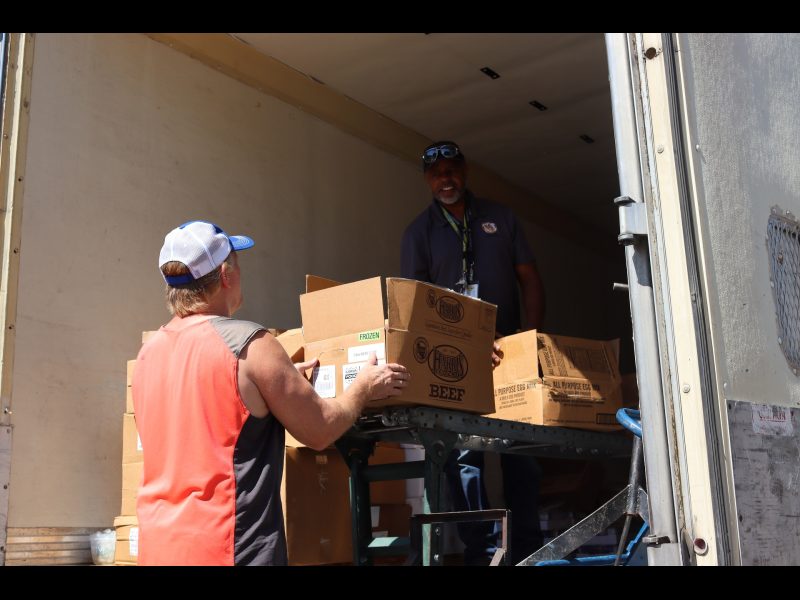 Tribal staff working with Specialist Ronald Buckman exchange information while fulfilling recipients distributions. California Valley Miwok Tribe staff member Tiger Paulk is helping Ronald Buckman to unload good supplies.