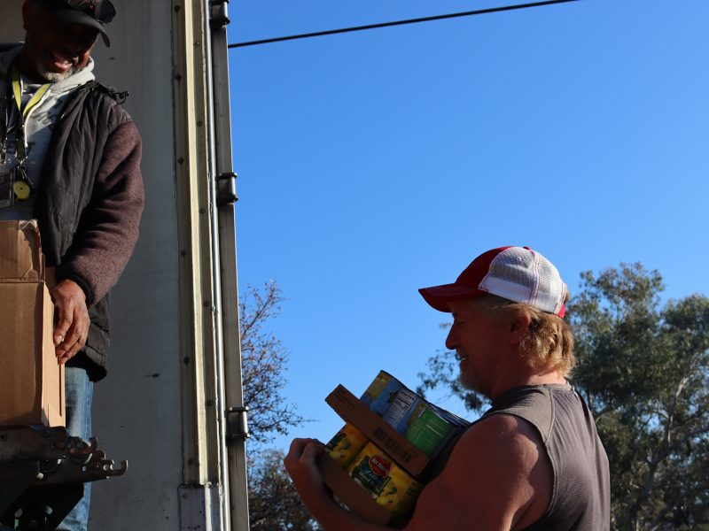 Ronald Buckman and tribal staff during the unloading of distributions. California Valley Miwok Tribal staff Tiger Paulk is carrying delivery goods.
