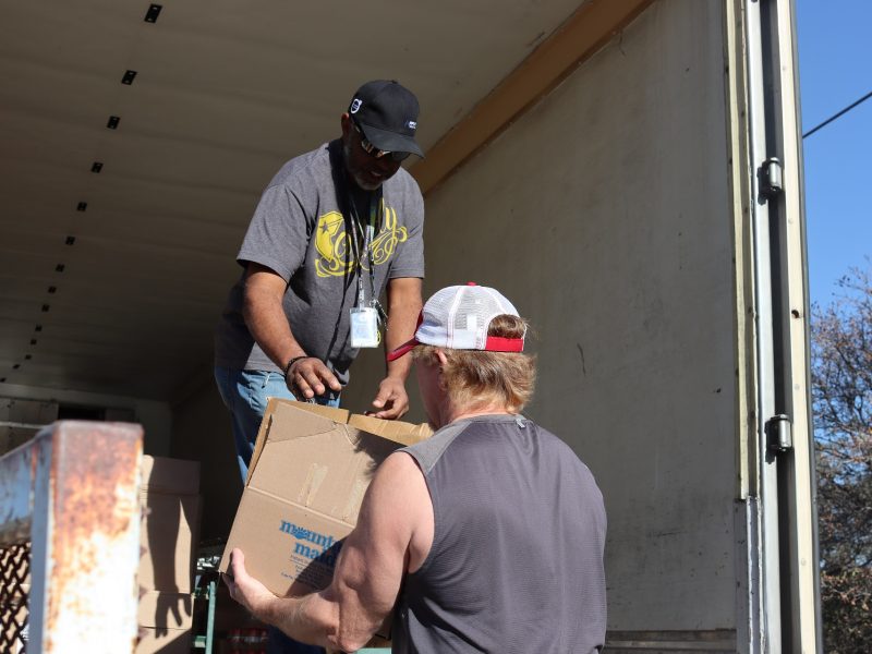Ronald Buckman handing a box of goods to California Valley Miwok Tribal staff Tiger Paulk.