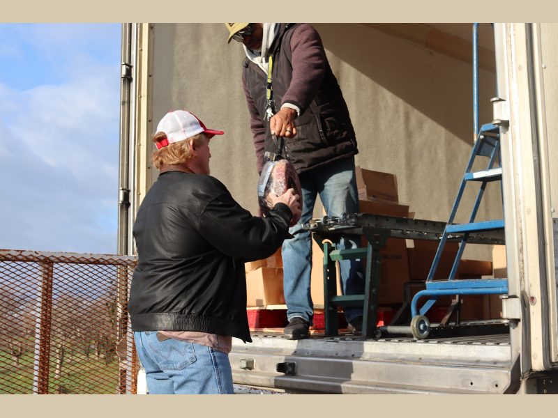 Ronald Buckman giving holiday ham to Tiger Paulk, CVMT tribal staff.