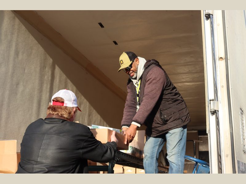 Ronald Buckman assists tribal staff unloading goods.