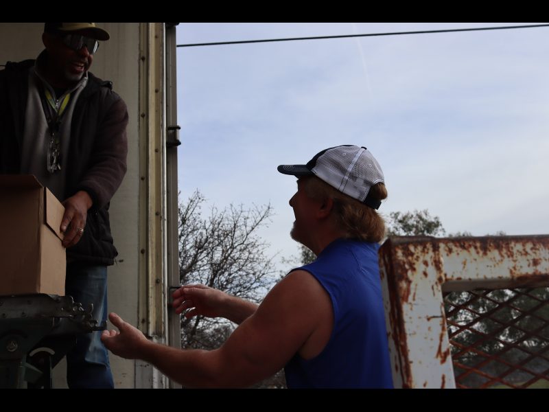 More boxes of food and more things to discuss as working just melts
away the time during distribution. Ronald Buckman and Tiger discussins while unloading boxes of goods.