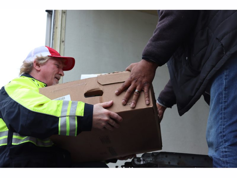 During a very short break in the weather food was unloaded as rapidly
as possible. California Valley Miwok Tribal staff unloading goods.