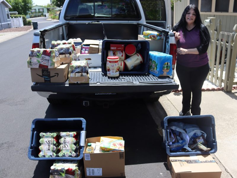 California Valley Miwok Tribal Chairperson, ( Silvia Burley ) stands with what is left of distribution during unloading process.