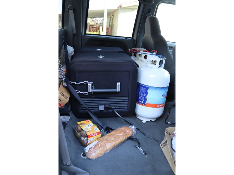 Various items pictured including food, propane and portable ice box that carries frozen items on the journey to (FFTF) Program Director, Mildred Burley's on site tribal freezer. Propane and portable ice box in truck.
