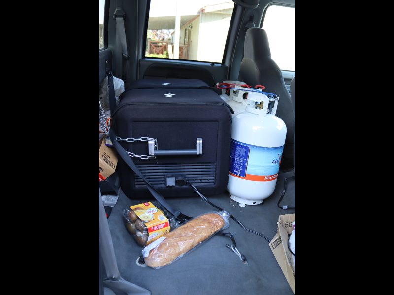 Various items pictured including food, propane and portable ice box that carries frozen items on the journey to (FFTF) Program Director, Mildred Burley's on site tribal freezer. Propane and portable ice box in truck.