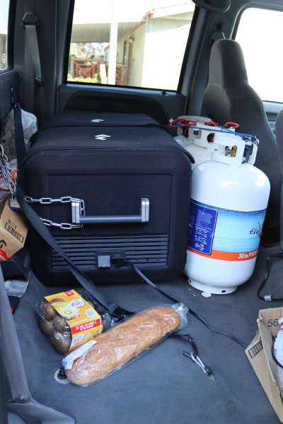 Various items pictured including food, propane and portable ice box that carries frozen items on the journey to (FFTF) Program Director, Mildred Burley's on site tribal freezer. Propane and portable ice box in truck.