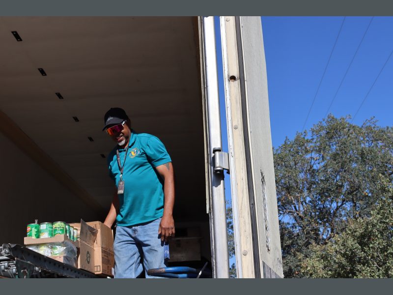 Ronald Buckman helping tribal staff Tiger Paulk to unload goods for the Native tribes, on October 2023.