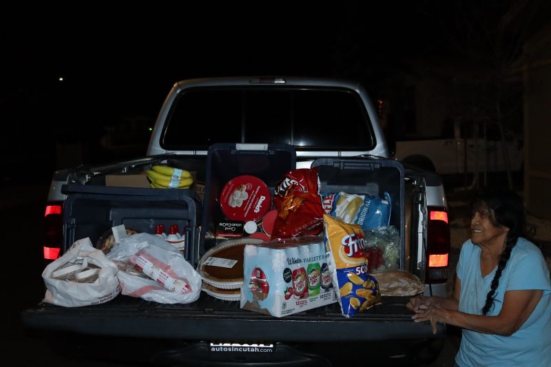 An array of frozen meats, pies, festive snacks, fruits,
creamers, sodas, vegetables and breads and of course a very jubilant Food For Tribal Families Program Director. California Valley Miwok Tribal elder Mildred posing in front of foods to be delivered to Native families.