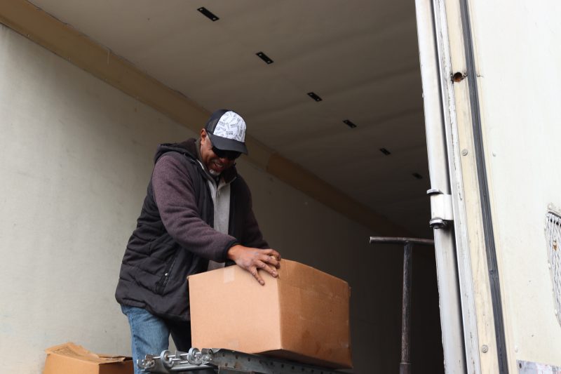 Ronald Buckman rolling some goods box on a conveyor.
